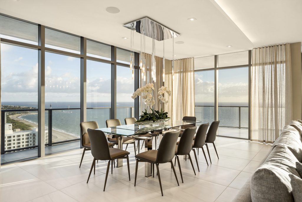 Dining room with floor-to-ceiling ocean views in Solemar penthouse UPH03, Pompano Beach